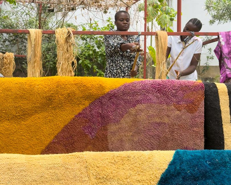 Load video: Short documentary filmed in Kinshasa showing Congolese designer Jess Kilubukila and women artisans weaving Kuba-inspired raffia textiles using Mandombe visual patterns. The video documents the Kilubukila workshop, contemporary African design processes, collaborative textile production, and the transformation of Congolese cultural heritage into a structured creative economy model through design, training, and entrepreneurship.